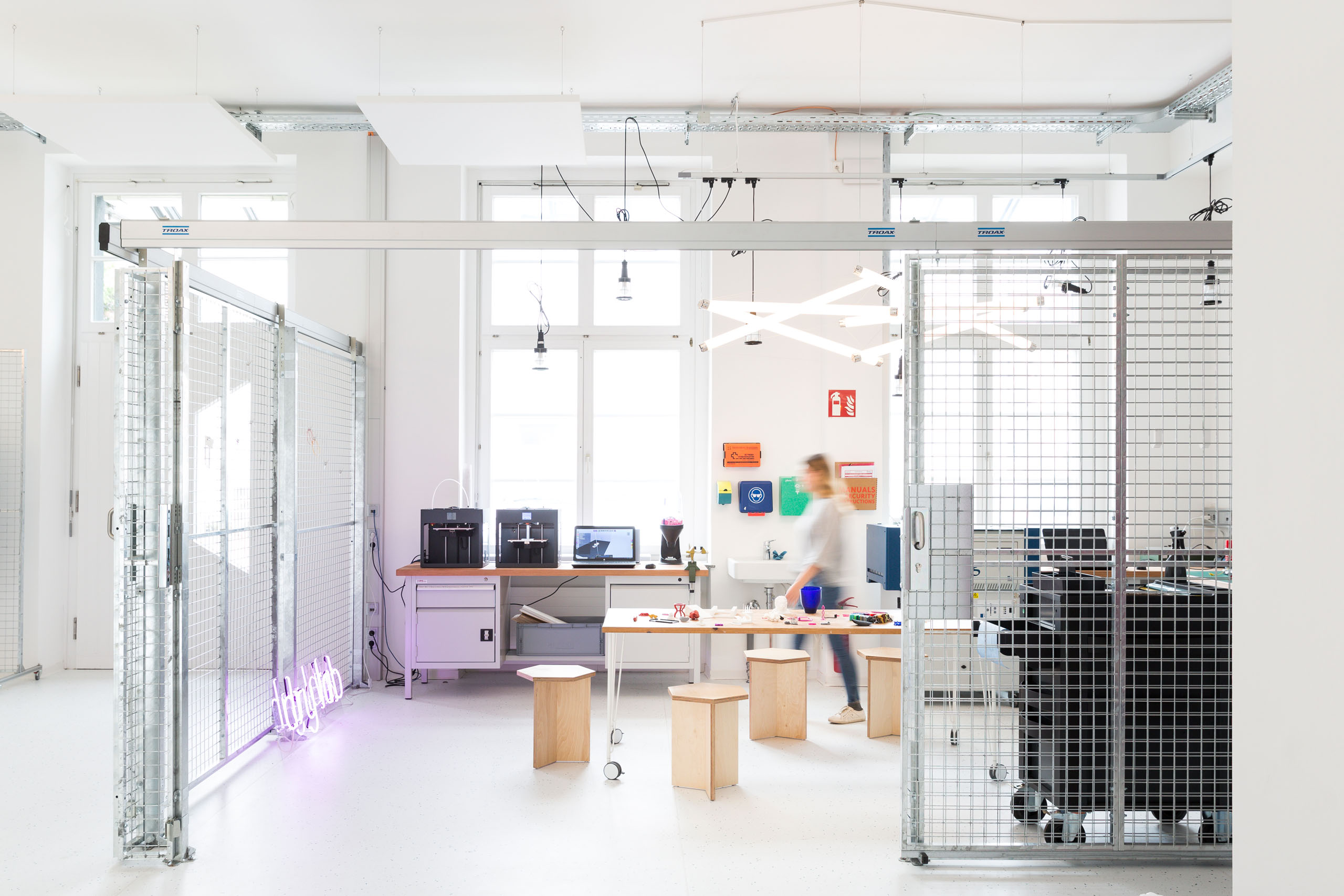 The interior of a lab working space with a person walking through.
