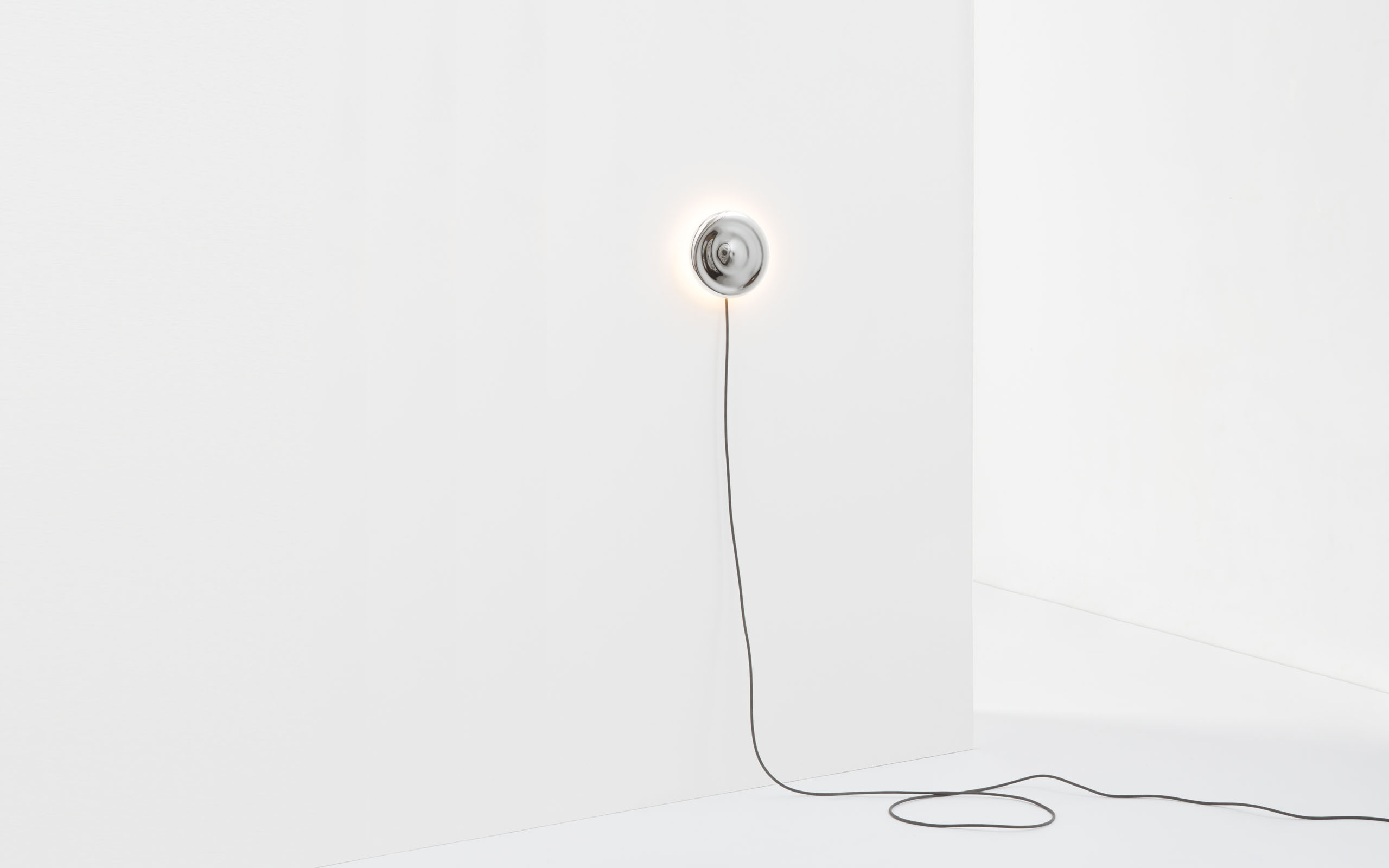 A thumbnail of the wall light. The mirrored body of the light is hanging in an empty white room.