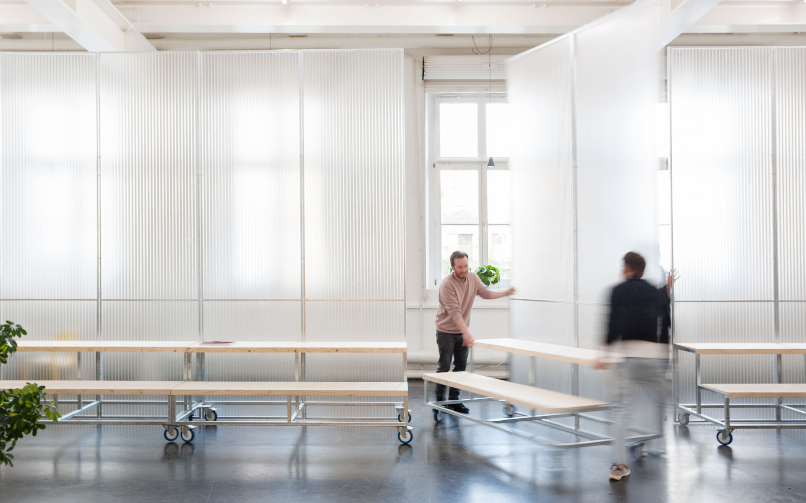 Two people handling a mobile structure in the Neue Denkerei.